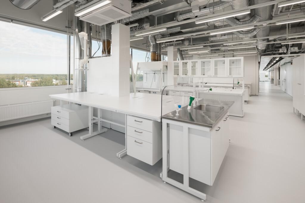 A bright laboratory featuring various work surfaces and a sink.